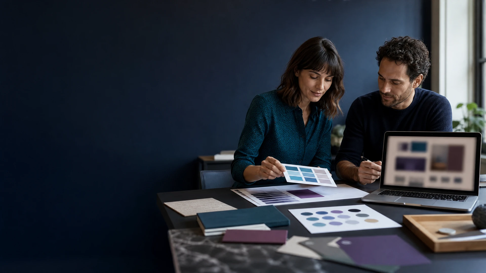 Creative professionals reviewing brand materials and a website concept.